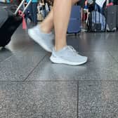Person pulling a suitcase seen from legs down