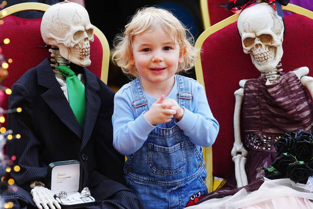 Two-year-old Luca Patterson with two toy skeltons